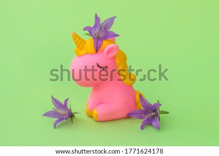 Little pink unicorn figure with flowers