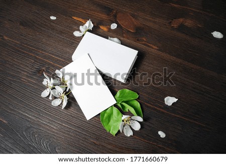 Blank white business cards and flowers on wood table background. Mockup for ID. Template for graphic designers portfolios.
