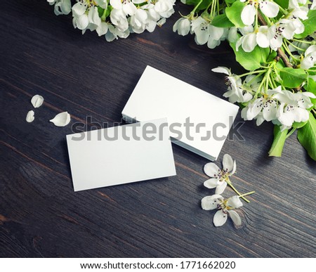 Blank business cards template and flowers on wooden background. Template for graphic designers portfolios.