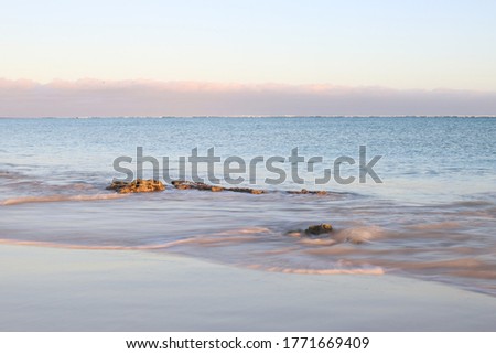 waves washing over rock at sunrise