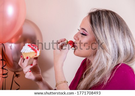 Blonde woman eating birthday cupcake