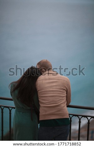 Beautiful walking couple cuddling. View from the back. Nice colors with blurred background