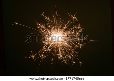New Year Christmas sparkler on dark background with bokeh lights