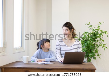 A pregnant woman working at home and a child watching
