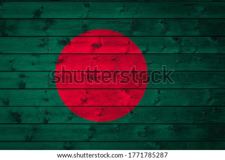 The national flag of Bangladesh is painted on a camp of even boards nailed with a nail. The symbol of the country.
