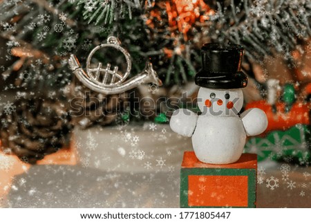 wooden Christmas tree snowman toy on the background of festive illumination