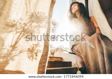 Beautiful woman in blue pajamas drinking coffee at the morning.  Royalty-Free Stock Photo #1771846094