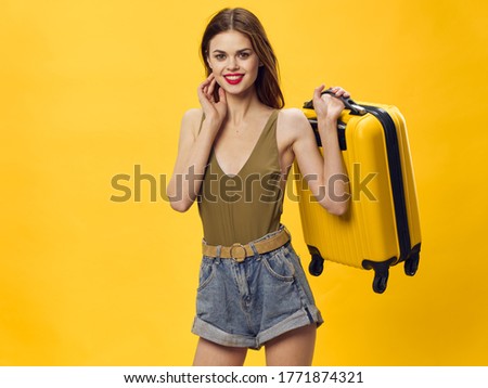 A woman with a suitcase goes on a trip and smiles at the camera