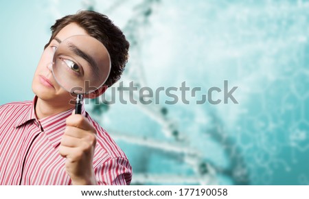 Young man in casual looking in magnifier
