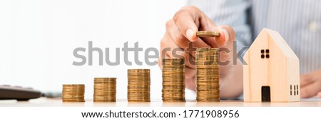 Property investment and house mortgage financial concept, hand of a businessman who is stacking coins for Real estate investment, saving for buying for housing or speculation Royalty-Free Stock Photo #1771908956