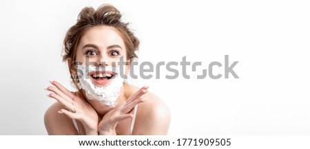 Beautiful young caucasian woman with shaving foam on her face posing on white background