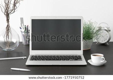 Workspace with laptop mock up. Dark wooden desk and white wall. Front view. Clipping path round laptop screen. 3d illustration