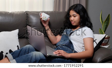 A teen girl enjoys to learn from home.