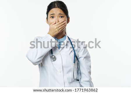 Frightened woman doctor in a medical coat covered her face 