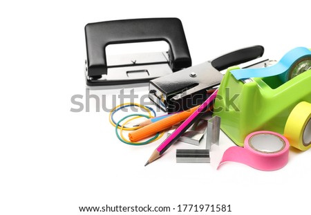 Office supplies, tape holder, paper puncher, stapler, rubber bands, staples, isolated on white background