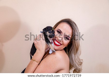 Blonde woman holding puppy in hand