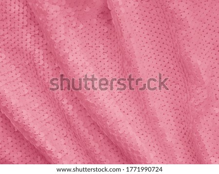 
Background fabric sequin in pink color. Holiday abstract glitter background with blinking lights. Fashion fabric glitter. 