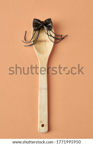 Cartoon girl with a bow from farfalle pasta and wooden spoon, conceptual photography for food blog or ad