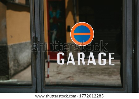 European signs - Garage and No Parking. A glass door with the signs and a note in the small Italian city - Parma, Emilia Romagna, Italy. 