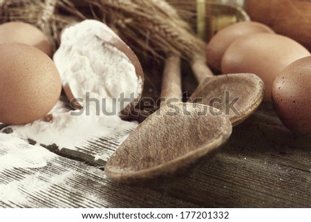 gray photo of spoons and flour 