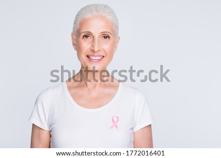 Close up photo of charming lady looking at camera holding pink symbol on her stylish t-shirt isolated over white background
