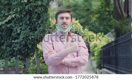 Portrait of male with medical mask with Brazil flag. Serious.Everything is OK sign.

