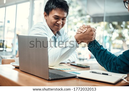Two Business people Competing In Arm Wrestling