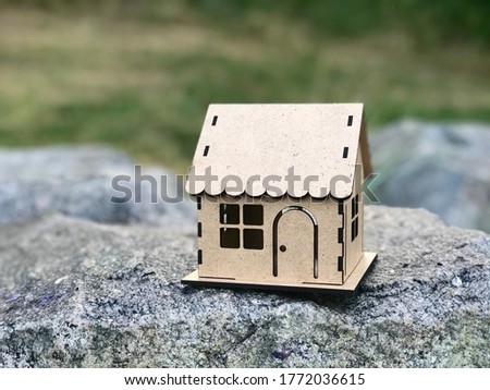 Сardboard house on natural background. Concept of real estate investment. Concept of home and family. Copy space for your text, housewarming  postcard.
