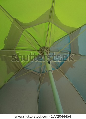 Detail of a green beach umbrella seen from below