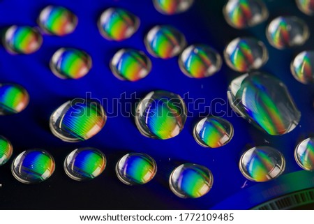Macro shot of water drops on a CD surface for an abstract background.