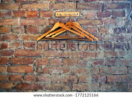 Bricks wall background with rack and wooden clothes hangers, cafe restaurant wardrobe corner, loft style  Royalty-Free Stock Photo #1772125166