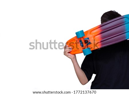 young boy holding colorful skateboard in hand and white background