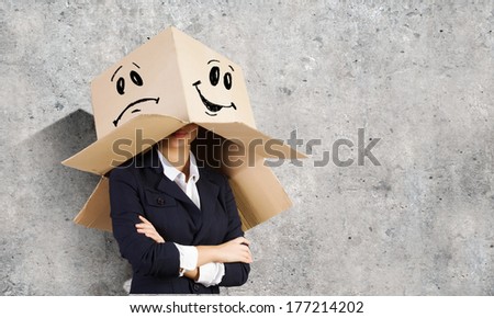 Businesswoman wearing carton box with drawn smiley on head