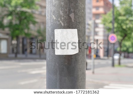 Square blank sticker mockup on the street glued to the pillar. White textured label template.