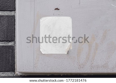 Rectangular blank sticker mockup on the street glued to the wall. White textured label template.