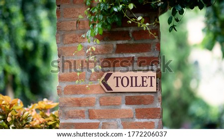 Toilet signs are on the wall of the Red Dang and there are forest areas.