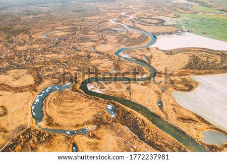 Aerial View Of Dry Grass And Partly Frozen River Landscape In Late Autumn Day. High Attitude View. Marsh Bog. Drone View. Bird's Eye View Royalty-Free Stock Photo #1772237981