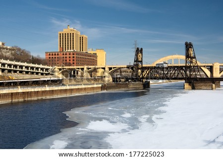 Snow and ice covered Mississippi River with railroad track and Robert Street Bridge. Saint Paul, Minnesota, USA