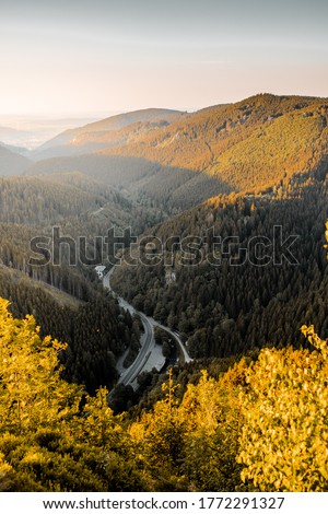 Beautiful idyllic mountain sunset view into the valley with colorful sunligh on a nice autumn outdoor day with fall orange leaves. Harz Mountains, Harz National Park in Germany. Royalty-Free Stock Photo #1772291327