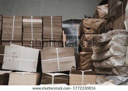 pallets with boxes, products are packed in paper and stacked in piles at the finished goods warehouse. Cardboard factory concept. Selective focus