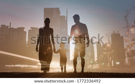 Family silhouette walking together in modern urban city. Double exposure