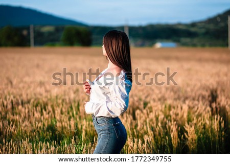 Portrait of a girl in a wheat field. Girl in a shirt on a wheat field. Portrait of a beautiful girl in a shirt on a wheat field. Girl in a shirt. Wheat field.