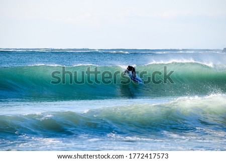 Surfer on Blue Ocean Wave riding on surfing board in Asia.  Japan is famous for its great waves near to Tokyo City