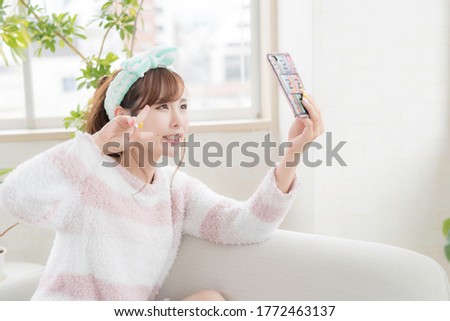 
A woman taking a selfie with a smartphone