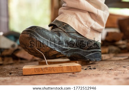 Worker in safety shoes stepping on nails on board wood In the construction area Royalty-Free Stock Photo #1772512946