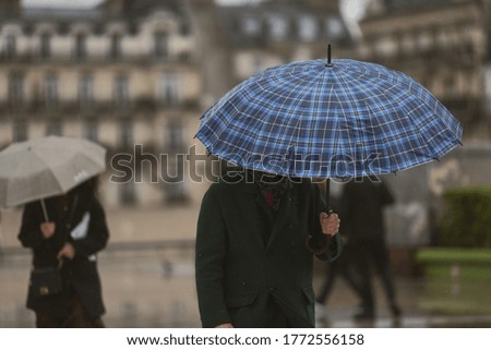 People with an umbrella in a rainy day in Paris