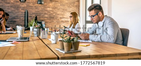 Young businessman working in a coworking office with his colleagues