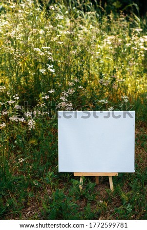 White empty mockup template poster canvas painting on green leaves background