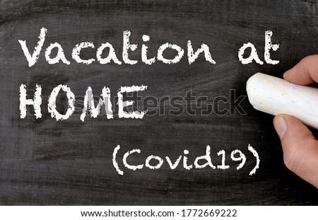 Vacation at home covid19 handwritten on chalkboard