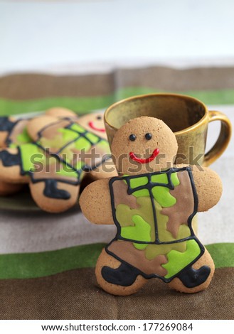Homemade Gingerbread men in protective khaki uniforms on Defender of the Fatherland Day, selective focus